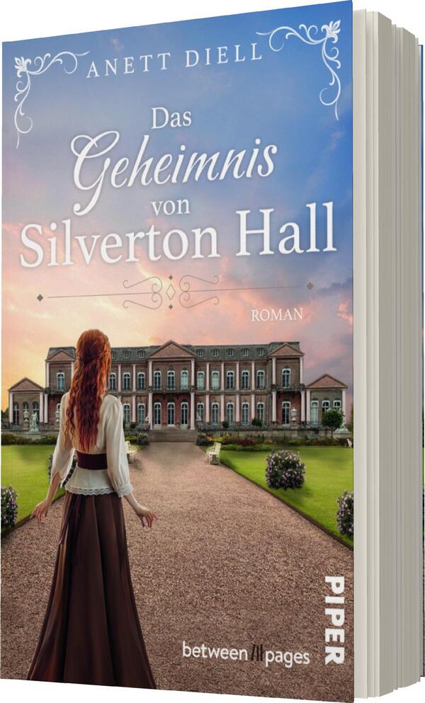 Das Buchcover zeigt eine elegante Frau mit langen, rotbraunen Haaren, die in einem historischen Kleid mit weißen und roten Elementen gekleidet ist. Sie steht auf einem Weg, der zu einem prächtigen Gebäude führt, umgeben von gepflegten Gärten. Der Himmel ist in sanften Blau- und Rosatönen gehalten, was eine romantische Atmosphäre vermittelt. Der Titel „Das Geheimnis von Silverton Hall“ ist prominent und in verspielter Schriftart platziert. Darunter steht in kleinerer Schrift „Roman“.