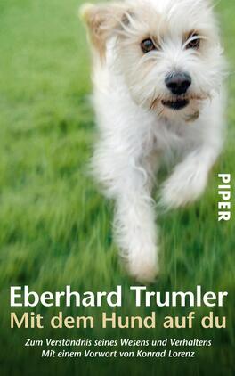 Mit dem Hund auf du Das Buchcover zeigt einen fröhlichen, weißen Hund, der auf einer grünen Wiese läuft. Der Hund hat strahlende Augen und ein lebhaftes, wuscheliges Fell, das die Energie und Freude widerspiegelt. Der Titel „Mit dem Hund auf du“ steht prominent in weißer Schrift auf einem dunklen Hintergrund, unter dem Autorennamen „Eberhard Trumler“. Darüber hinweg ist der Vermerk „Zum Verständnis seines Wesens und Verhaltens“ platziert, und das Cover enthält auch das Vorwort von „Konrad Lorenz“.