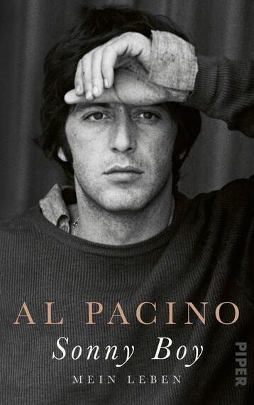 Das Buchcover zeigt ein monochromes Porträt von Al Pacino, der mit einer Hand die Stirn berührt und einen nachdenklichen Ausdruck hat. Der Hintergrund ist dunkel und schlicht gehalten, was den Fokus auf das Gesicht des Schauspielers lenkt. Der Titel „Sonny Boy“ ist in eleganter, goldener Schrift platziert, gefolgt von dem Untertitel „Mein Leben“ in kleinerer, ebenfalls goldener Schrift. Die Typografie vermittelt einen klassischen und zeitlosen Charakter.