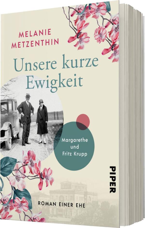 Das Buchcover zeigt eine nostalgische Szene, in der zwei Personen, ein Mann und eine Frau, in historischer Kleidung stehen. Im Hintergrund ist ein charmantes altes Auto abgebildet. Über dem Bild steht in eleganter Schrift „Unsere kurze Ewigkeit“, gefolgt von dem Namen der Autorin „Melanie Metzenthin“. Die Farbpalette umfasst sanfte Töne mit Blumenmotiven in Rosa und einem blauen Kreis, der „Margarethe und Fritz Krupp“ hervorhebt. Unten ist der Verlagsname „PIPER“ zu sehen.