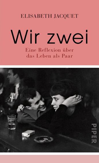 Das Buchcover zeigt einen rosafarbenen Hintergrund. In der oberen Hälfte steht der Titel „Wir zwei“ in großer, schwarzer Schrift. Darunter befindet sich der Untertitel „Eine Reflexion über das Leben als Paar“ in kleinerer, schwarzer Schrift. Das Cover zeigt zudem ein schwarz-weißes Bild eines Paares in einer Bar, das in naher Interaktion dargestellt ist, was eine intime Atmosphäre vermittelt. Im unteren rechten Bereich ist das Verlagslogo „PIPER“ zu sehen.