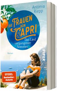 Das Buchcover zeigt eine sommerliche Capri-Ansicht mit blauem Meer und steilen Küsten im Hintergrund; im Vordergrund sitzt eine junge Frau in orangefarbenem Oberteil und dunklem Rock auf einer Mauer, nach unten blickend. Links oben oranges Obst an grünen Blättern. Mittig ein großer blauer Kreis mit dem Titel „Die Frauen von Capri“ und dem Untertitel „Das Lied vergangener Sommer“. Autorin: Antonia Riepp. Ein roter Button unten links: „SPIEGEL Bestseller-Autorin“.