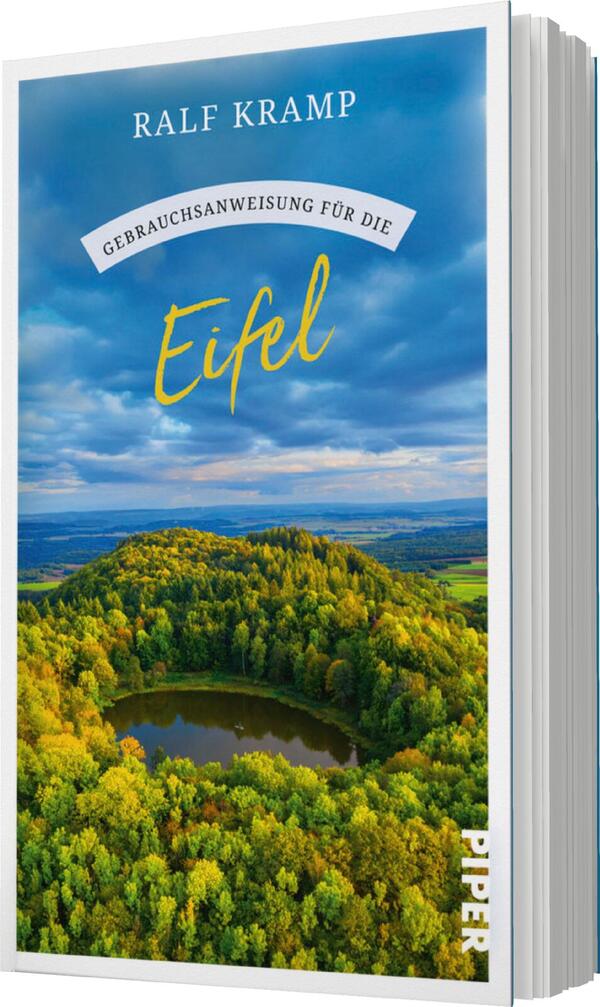 Das Buchcover zeigt eine malerische Landschaft der Eifel mit sanften Hügeln und bewaldeten Flächen, die in verschiedenen Grüntönen leuchten. In der Mitte des Covers ist ein kleiner, ruhiger See zu sehen, umgeben von einer dichten Baumgruppe. Der Himmel ist teilweise bewölkt und strahlt in sanften Blautönen. Oben befindet sich der Titel „Gebrauchsanweisung für die Eifel“ in einer eleganten, geschwungenen Schriftart, gefolgt vom Autorennamen „Ralf Kramp“ in einer klaren, serifenlosen Schrift.
