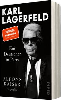 Das Buchcover zeigt ein porträtiertes Abbild von Karl Lagerfeld, der mit Sonnenbrille und charakteristischem Haarschnitt auftritt. Der Hintergrund ist überwiegend schwarz, was die Präsenz der Figur verstärkt. Der Titel „KARL LAGERFELD“ steht in großen, weißen Buchstaben oben, gefolgt von „Ein Deutscher in Paris“ in einer eleganten Schriftart. Unterhalb des Titels nennt sich der Autor „ALFONS KAISER“ in etwas kleinerer, heller Schrift. Eine auffällige rot-weiße Auszeichnung vermeldet „SPIEGEL Bestseller“.