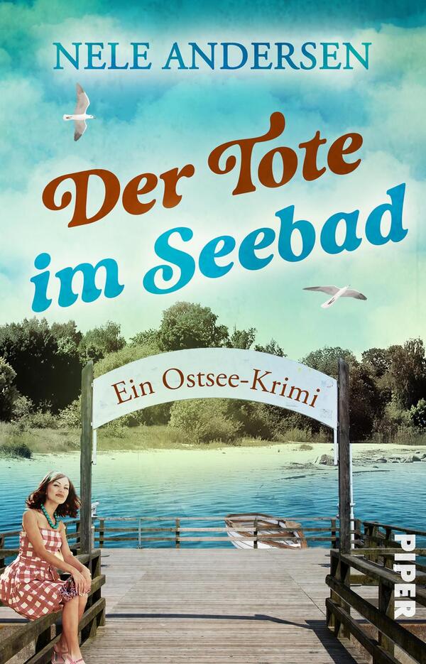 Das Buchcover zeigt eine malerische Szenerie mit einem steinernen Steg, der über einen ruhigen See führt. Im Hintergrund sind üppige Baumgruppen und ein blauer Himmel mit einigen Wolken und fliegenden Möwen zu sehen. Der Titel „Der Tote im Seebad“ ist prominent in einer verspielten Schriftart in Rot und Blau platziert. Unter dem Titel steht in kleinerer Schrift „Ein Ostsee-Krimi“. Die Atmosphäre vermittelt eine Mischung aus Ruhe und Spannung.