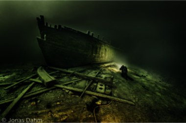 Geisterschiff: Taucher neben einem Schiffswrack unter Wasser