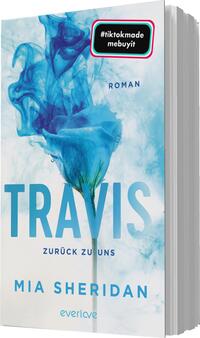 Das Buchcover zeigt einen sanften, hellblauen Hintergrund mit einem geschwungenen Rauchmuster, das eine mystische Atmosphäre erzeugt. Im Vordergrund befindet sich eine blaue Rose mit grünen Blättern. Der Titel „TRAVIS“ ist in großen, auffälligen Buchstaben in Dunkelblau gehalten, während der Untertitel „zurück zu uns“ und der Autorennamen „MIA SHERIDAN“ in einer schlichten Schrift darunter platziert sind. Oben links ist ein farbiger Sticker mit dem Text „#tiktokmade mebuyit“.