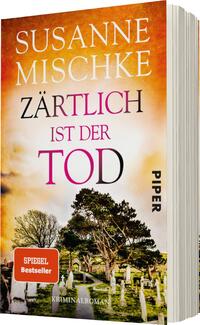 Das Buchcover zeigt eine stimmungsvolle Szenerie mit einem verwitterten Friedhof im Vordergrund, umgeben von knorrigen Bäumen. Der Himmel ist in warmen Orange- und Gelbtönen gehalten, was eine melancholische Atmosphäre schafft. Der Titel „Zärtlich ist der Tod“ ist in einer auffälligen, pinken Schriftart hervorgehoben, während der Autorennamen „Susanne Mischke“ oberhalb des Titels in eleganter, weißer Schrift steht. Das Cover enthält eine rote Auszeichnung „SPIEGEL Bestseller“ und ist dem Genre Kriminalroman zuzuordnen.