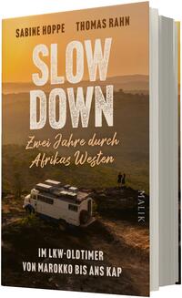 Das Buchcover zeigt eine gold-orangefarbene Abendstimmung über einer afrikanischen Landschaft mit Hügeln; im Vordergrund steht ein weißer Lkw-Oldtimer-Kleinbus auf einer Anhöhe, daneben zwei kleine Personenfiguren. Titel groß in weißen, rau gezeichneten Großbuchstaben: „SLOW DOWN“, darunter in kursiver Schreibschrift: „Zwei Jahre durch Afrikas Westen“. Autoren oben: Sabine Hoppe, Thomas Rahn. Unten weißer Untertitel: „Im Lkw-Oldtimer von Marokko bis ans Kap“.