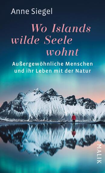 Das Buchcover zeigt eine beeindruckende Landschaft mit schneebedeckten Bergen, die sich in einem ruhigen Gewässer spiegeln. Im Vordergrund steht eine Person in rotem Anorak, die in die Ferne blickt. Der Himmel ist in sanften Rosa- und Blautönen gehalten, was eine mystische Atmosphäre erzeugt. Der Titel „Wo Islands wilde Seele wohnt“ ist in eleganter Schrift in Pink gehalten, während der Untertitel „Außergewöhnliche Menschen und ihr Leben mit der Natur“ in weißer Schrift darunter steht. Der Verweis auf den Verlag Malik ist am rechten Rand platziert.