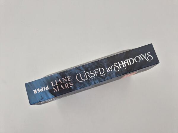 Außenansicht des Buches „Cursed by Shadows“