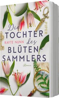 Das Buchcover zeigt eine helle, freundliche Gestaltung mit floralen Elementen, darunter pinke Lilien und grüne Blätter, die chaotisch angeordnet sind. In der oberen Mitte steht der Titel „Die Tochter des Blütensammlers“ in großen, verspielten Buchstaben, während der Autorenname „Kayte Nunn“ in einer kleineren, eleganten Schrift darunter platziert ist. Ein detailliertes Vergrößerungsglas und eine altmodische Schere ergänzen das Design und verleihen ihm eine nostalgische Atmosphäre.