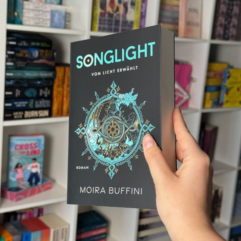 "Songlight" von Moira Buffini wird vor einem Bücherregal gehalten.