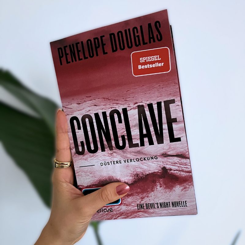 „Conclave“ von Penelope Douglas wird in einer Hand gehalten
