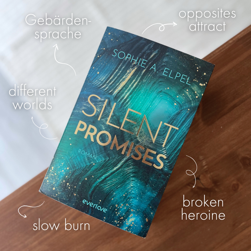 „Silent Promises“ von Sophie A. Elpel liegt auf einem hözernen Untergrund. Außenherum stehen die Tropes „Slow Burn“, „Opposites attract“, „Gebärdensprache“, „Broken Heroine“ und „different worlds“.