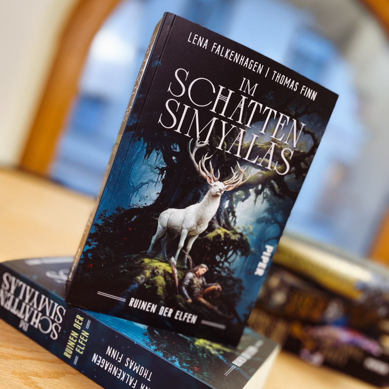 Zwei Exemplare von „Im Schatten Simyalas“ von Lena Falkenhagen und Thomas Finn auf einem Tisch