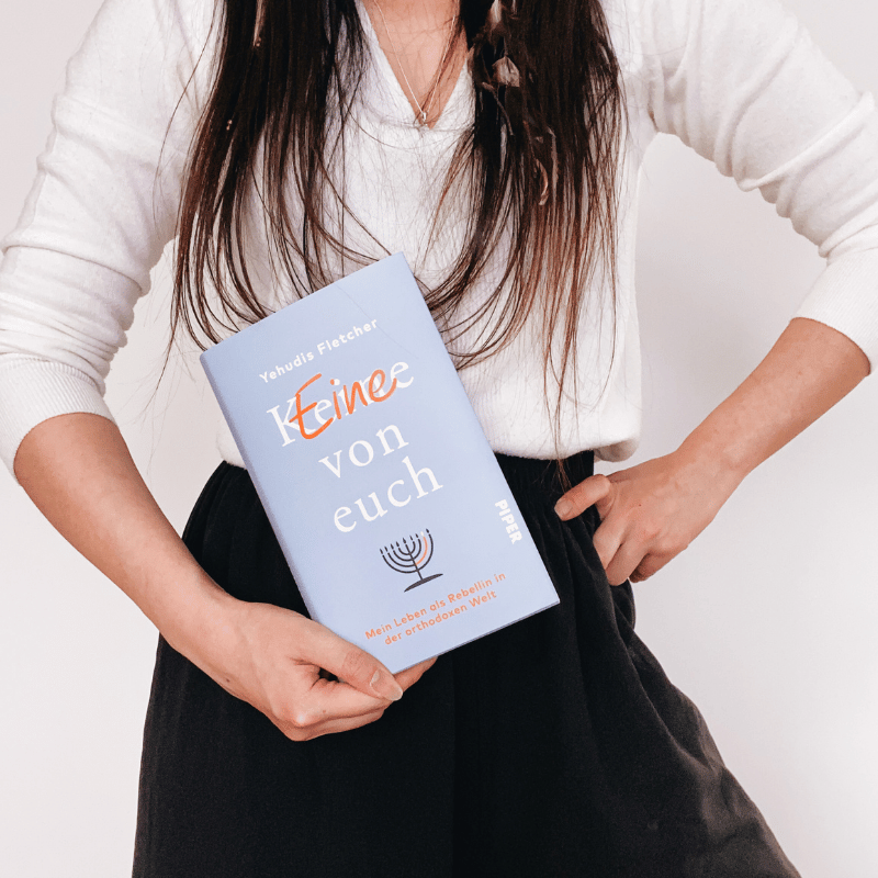 Eine Person hält das Buch „(K)Eine von euch“ von Yehudis Fletcher