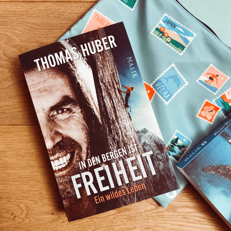 „In den Bergen ist Freiheit“ von Thomas Huber liegt auf einem Holzboden