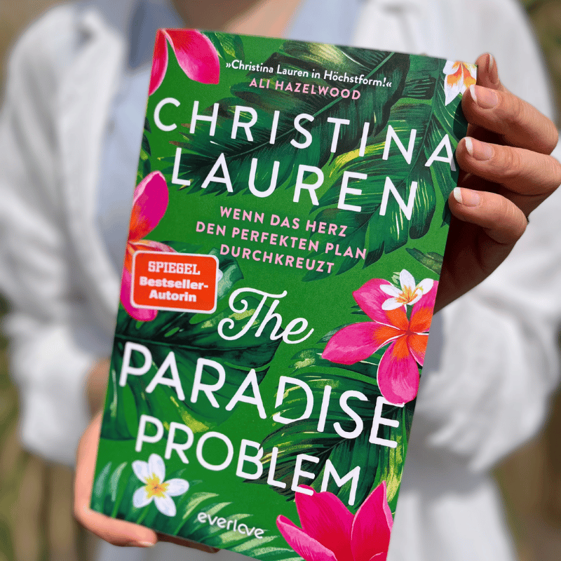 „The Paradise Problem“ von Christina Lauren wird von einer Person gehalten