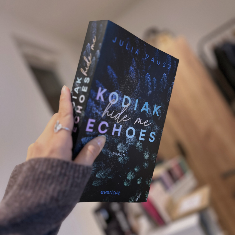 „Kodiak - Hide Me Echoes“ von Julia Pauss wird von einer Hand gehalten