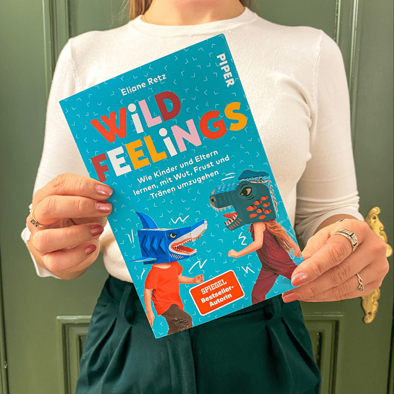 „Wild Feelings“ von Eliane Retz wird von einer Person in die Kamera gehalten