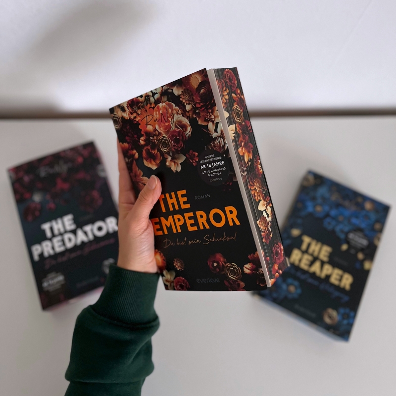 Eine Hand hält „The Emperor“, „The Predator“ und „The Reaper“ liegen im Hintergrund