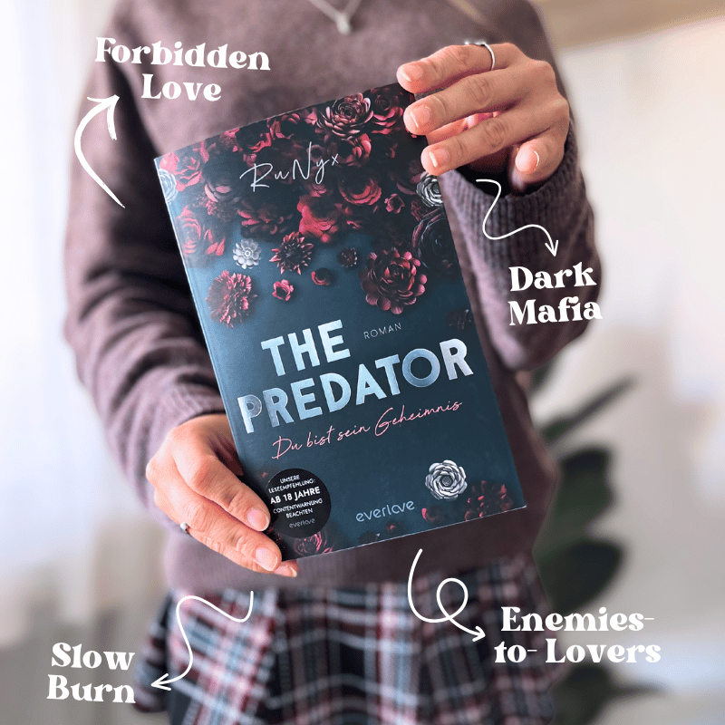 „The Predator – Du bist sein Geheimnis“ von RuNyx wird von einer Person in die Kamera gehalten