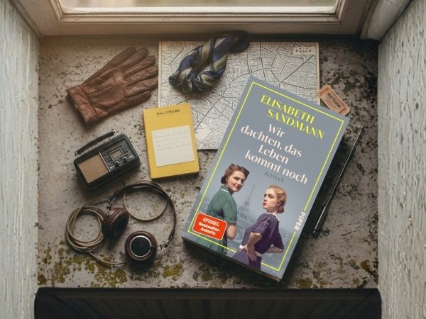 Der Roman "Wir dachten, das Leben kommt noch" umgeben von historischen Agentenutenslilien