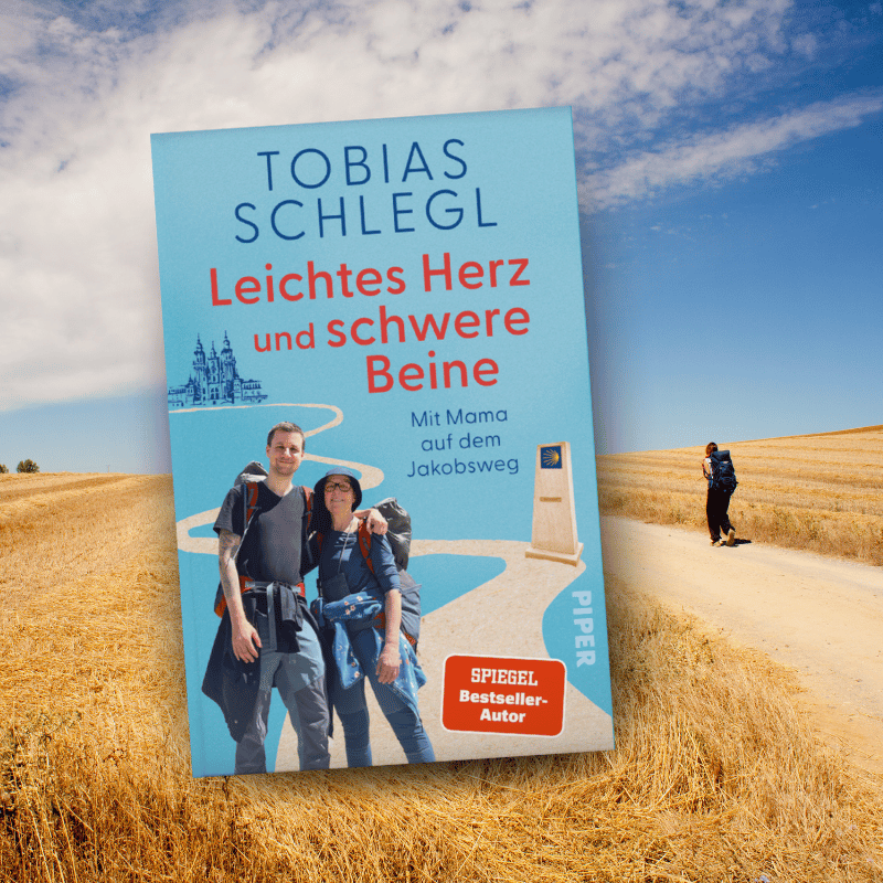 „Leichtes Herz und schwere Beine“ von Tobias Schlegl wird vor einer Jakobsweg-Kulisse gezeigt
