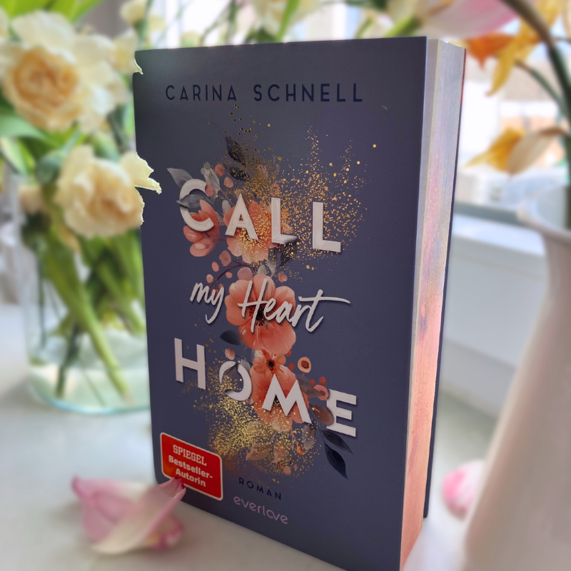 „Call My Heart Home“ von Carina Schnell steht vor Blumen