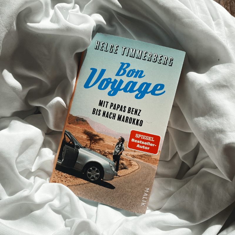 „Bon Voyage“ von Helge Timmerberg liegt auf hellem Stoff