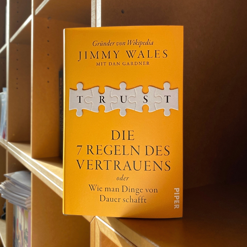 „Trust“ steht in einem hölzernen Bücherregal