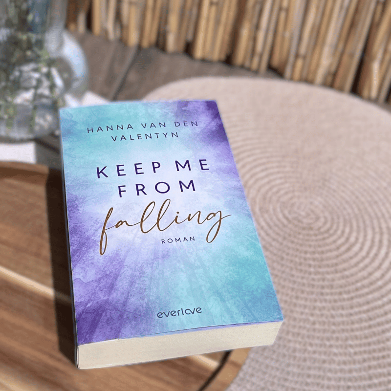 „Keep Me From Falling“ von Hanna van den Valentyn liegt auf einem Holztisch